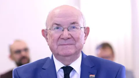 Portret Krešimira Ćosića u plavom odelu i naočalama