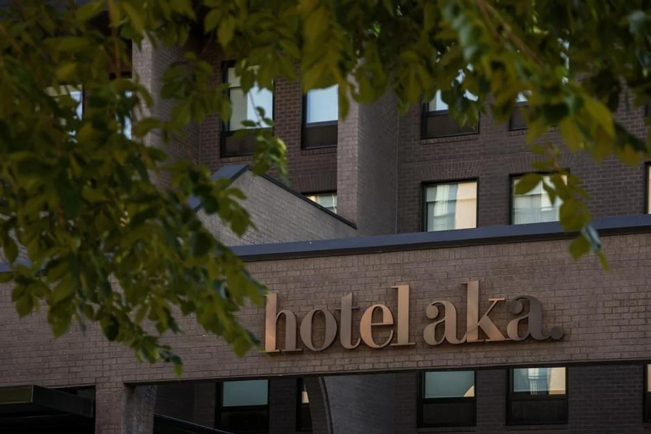 Krupni plan natpisa Hotel AKA djelomično zaklonjen lišćem drveta
