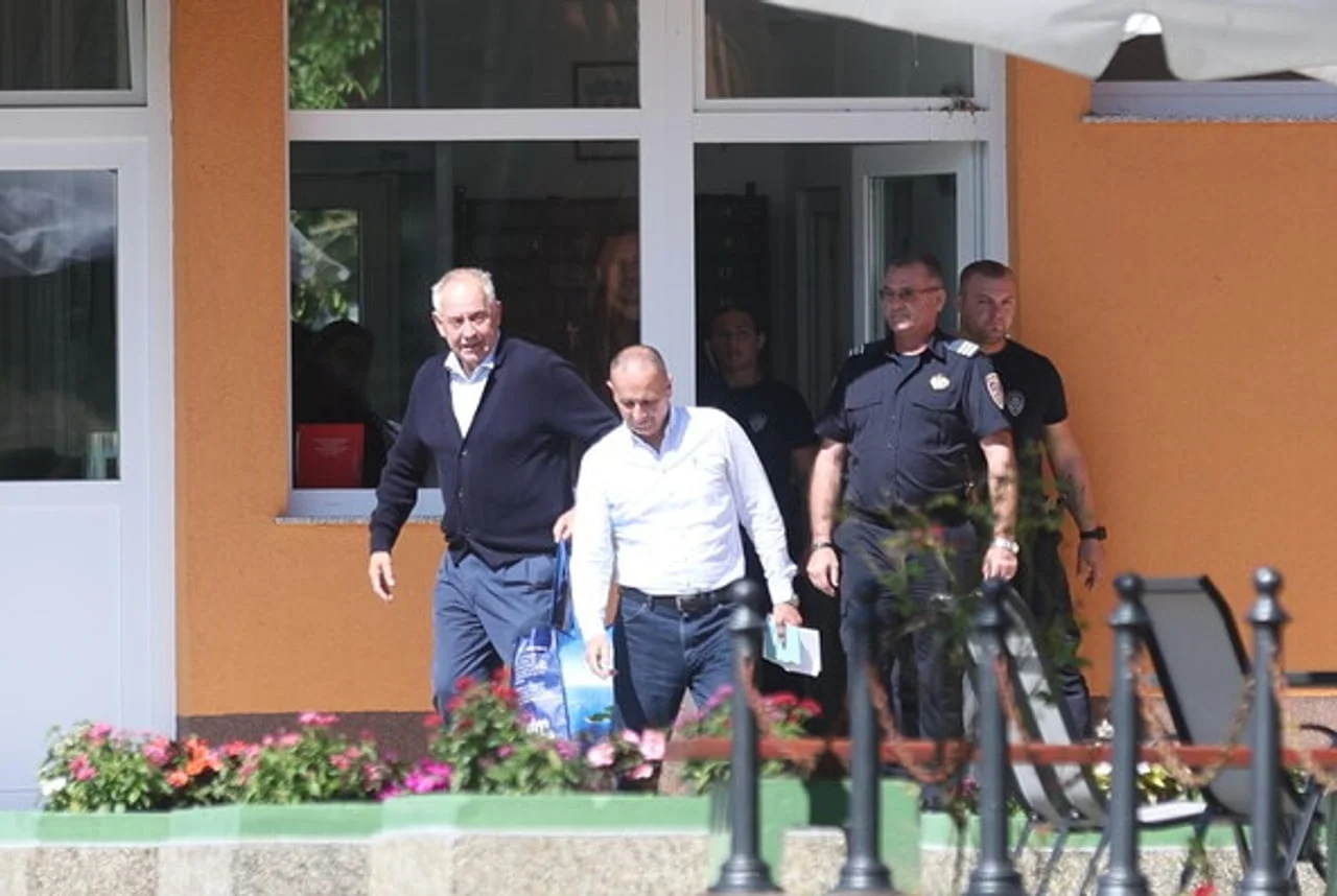 Ivo Sanader u bijeloj košulji u pratnji policije ispred zgrade