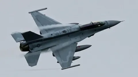 Sivi turski lovac F-16 u letu na sivom nebu