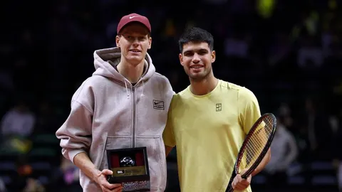 Tenisači Jannik Sinner i protivnik u sportskoj odjeći s trofejem