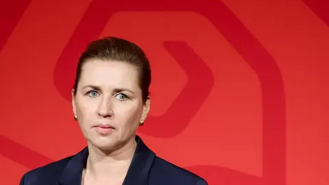 Portret danske premijerke Mette Frederiksen ispred crvene pozadine