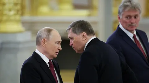 Vladimir Putin u razgovoru s muškarcem u crnom odelu