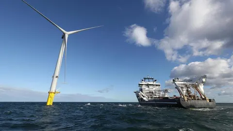 Veliki specijalizirani brod pored morskog vjetrora u plavom oceanu