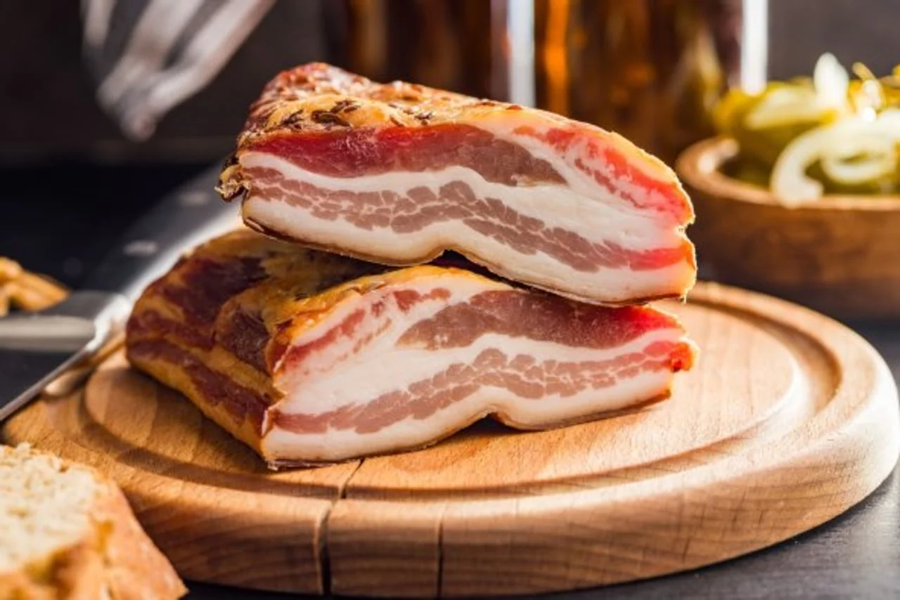 Slojevi masne i mesne slanine naslagani na drvenoj daski za rezanje
