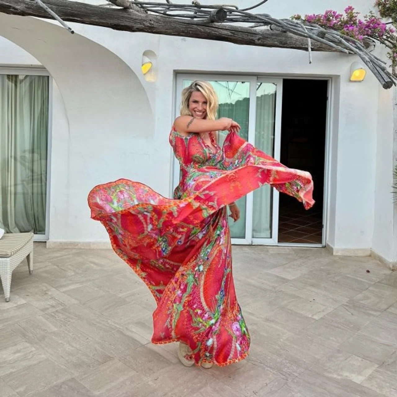 Nasmijana Michelle Hunziker u dugoj šarenoj haljini