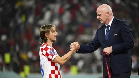 Luka Modrić u dresu Hrvatske rukuje se s predstavnikom Fifie u odelu