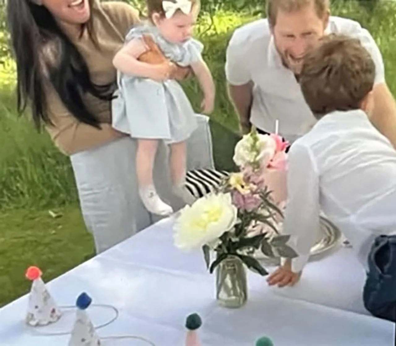 Obitelj slavi rođendan uz tortu i cvijeće na otvorenom