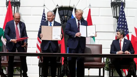 Donald Trump i Benjamin Netanyahu drže potpisane dokumente za stolom