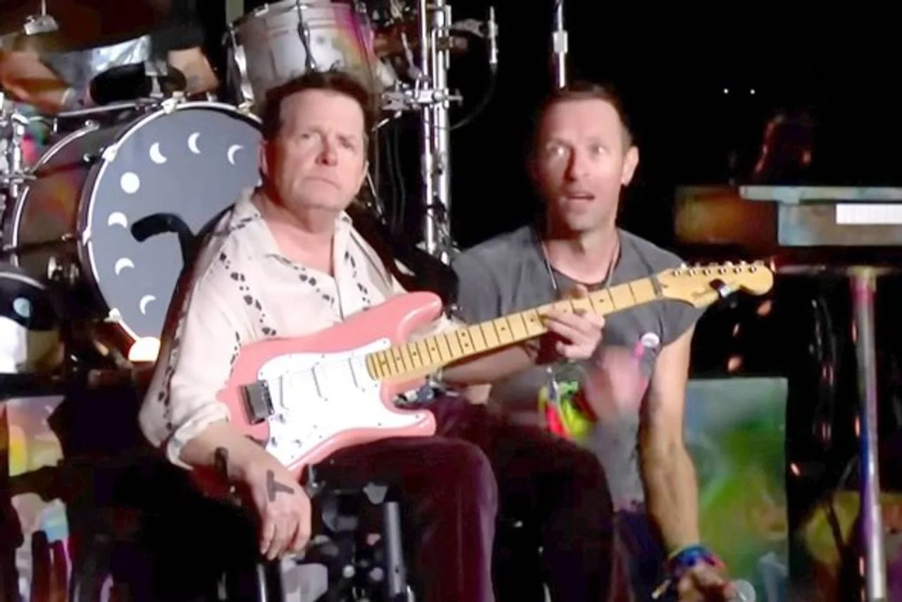 Michael J. Fox s električnom gitarom pored glazbenika na sceni