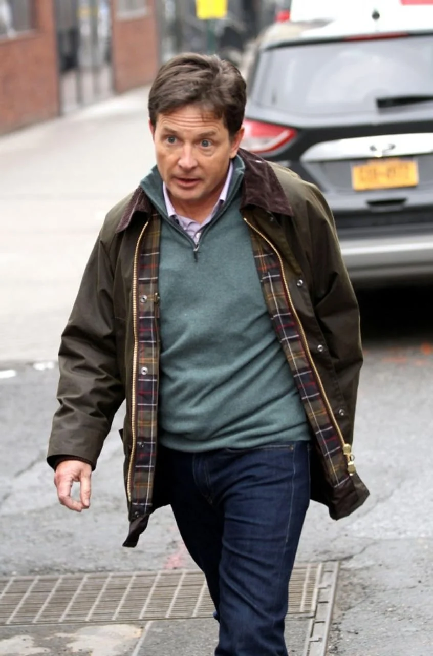 Michael J. Fox u smeđoj jakni i trapericama na ulici