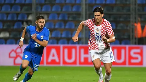 Nogometni igrač hrvatske reprezentacije u crveno-bijelim kockicama u akciji