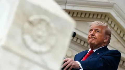 Donald Trump u tamnoplavom odelu i crvenoj kravati na govornici