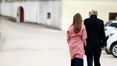 Muškarac u crnom kaputu i žena u ružičastom kaputu snimljeni s leđa