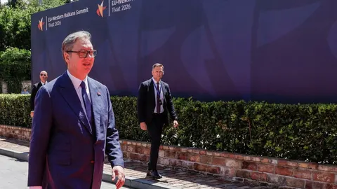 Aleksandar Vučić u tamnoplavom odelu ispred plavog zastavnog zida