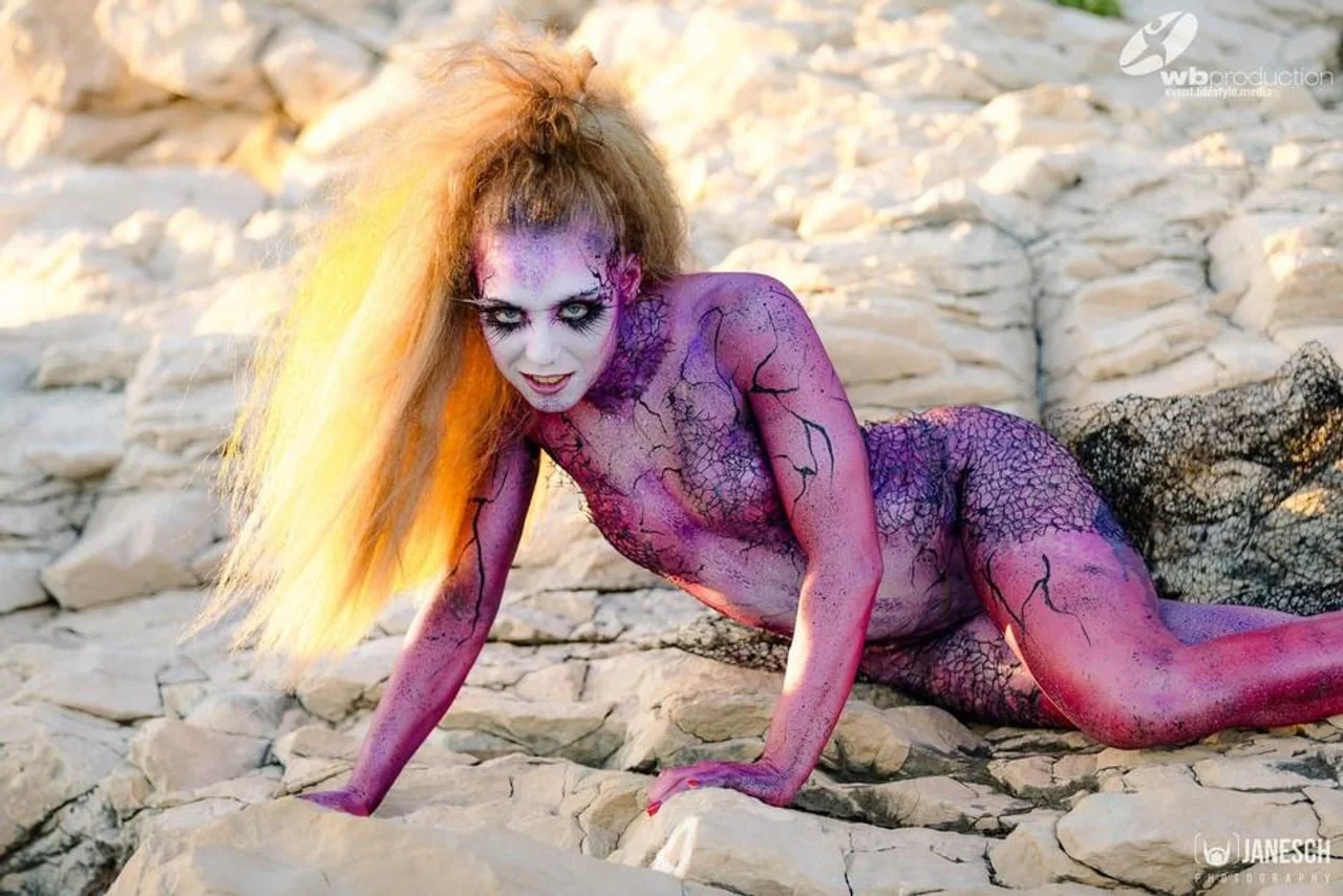 Žena s ljubičastim bodypaintingom i efektom napukane kože