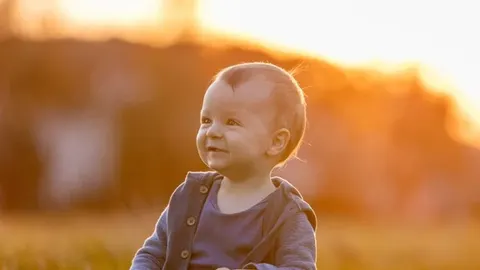 Smiješeće dijete u plavoj odjeći na sunčanom polju
