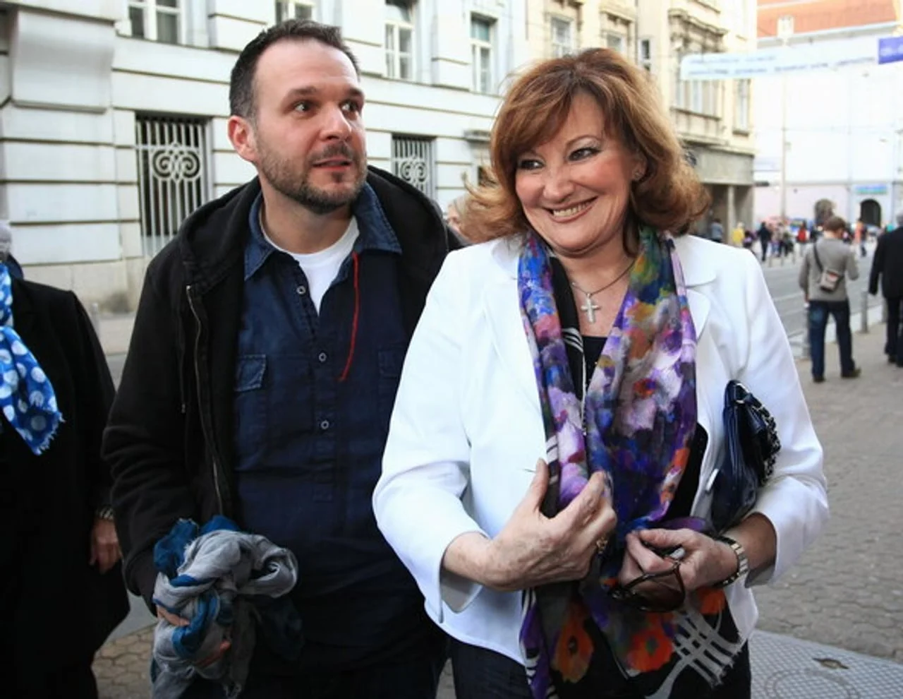 Tereza Kesovija u bijelom saku i šarenoj marami uz muškarca na ulici