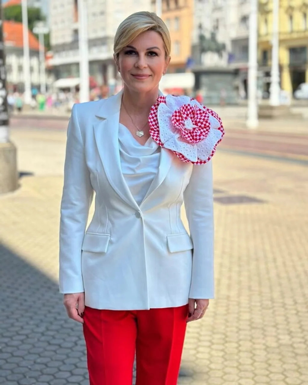 Kolinda Grabar-Kitarović u bijelom saku s velikom crvenom šnalom