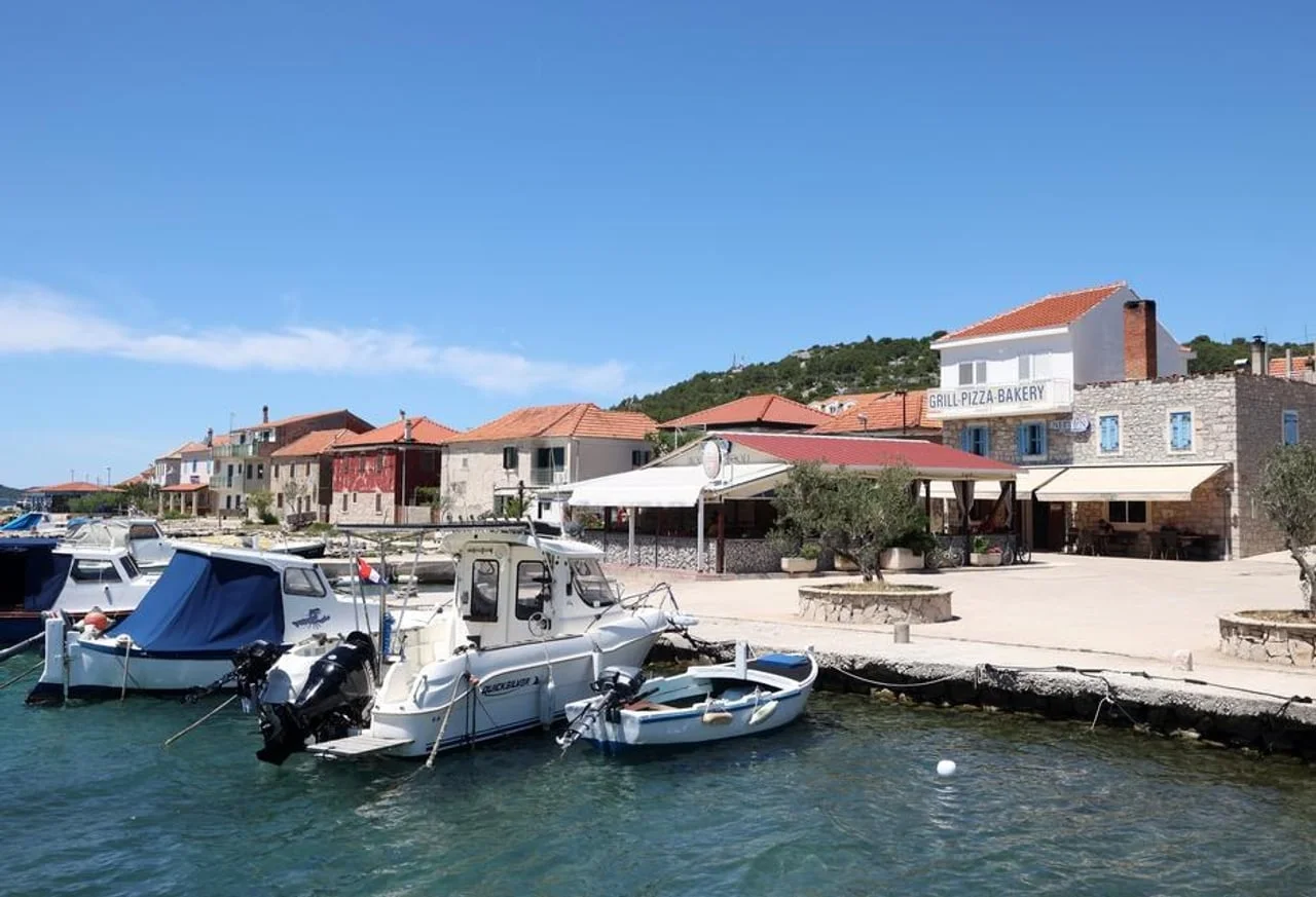 Plaža s privezanim brodovima i restoranom na obali