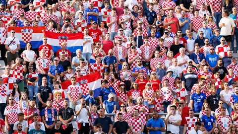Masa navijača u crveno-bijelim kockastim dresovima na nogometnom stadionu