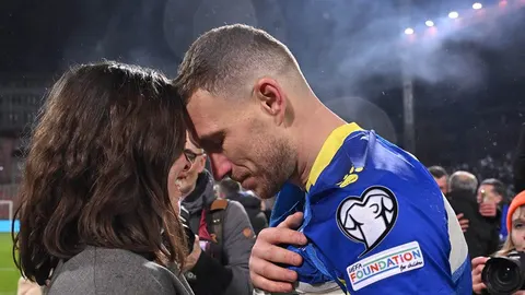 Edin Džeko u plavom dresu grli ženu i naslanja čelo na njezino čelo