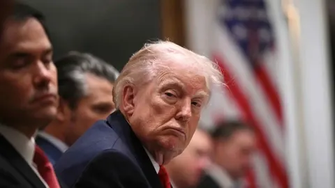 Donald Trump s ozbiljnim izrazom lica ispred američke zastave