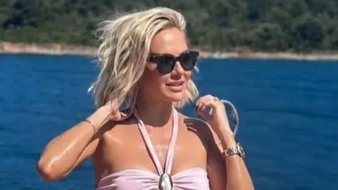 Portret plavuše u ružičastom kupaćem kostimu na jahti