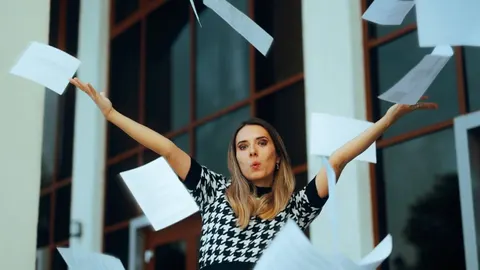 Sretna žena baca papire u zrak ispred poslovne zgrade