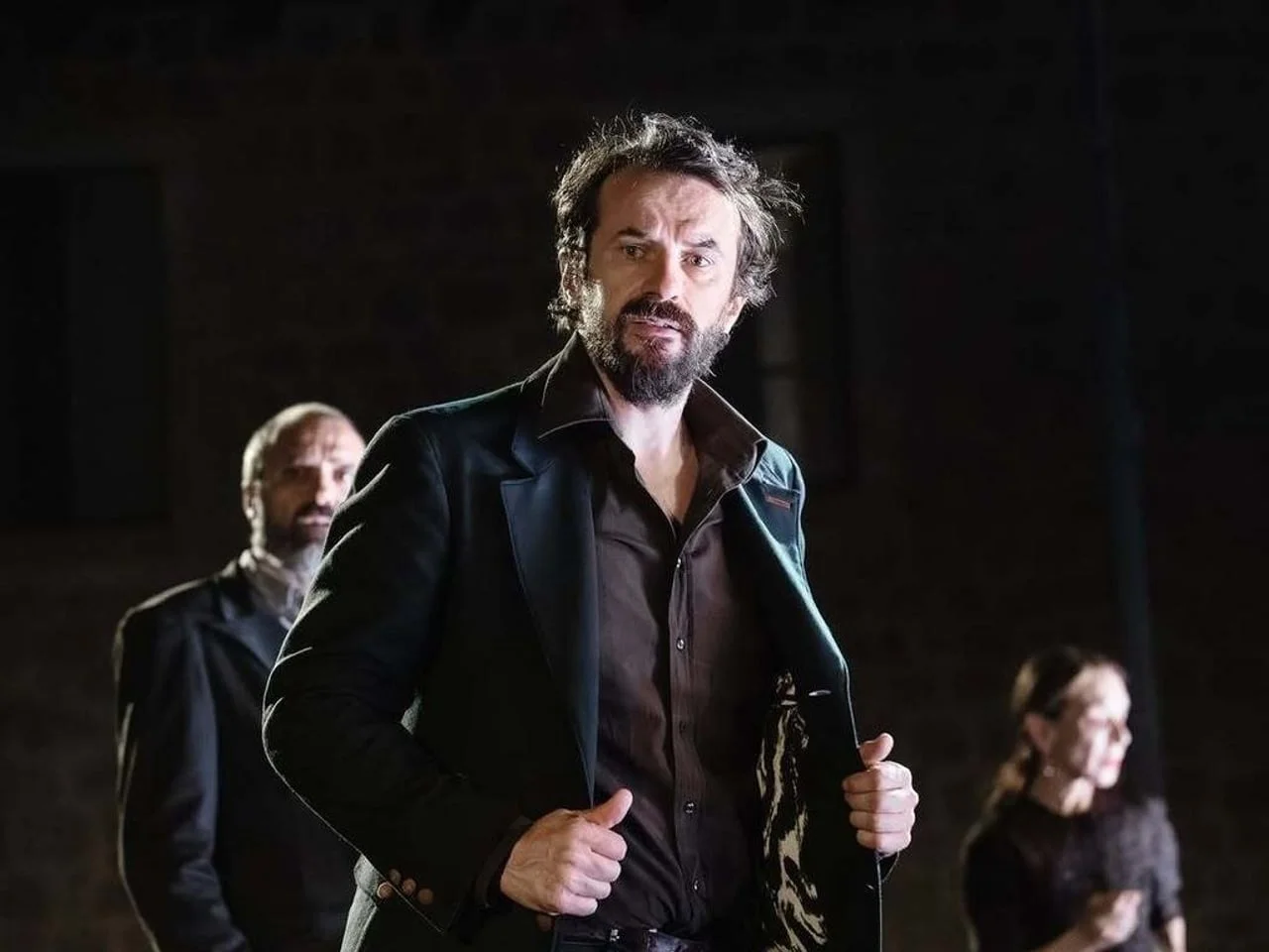 Igor Kovač u sceni iz predstave, odjeven u tamni sako i košulju