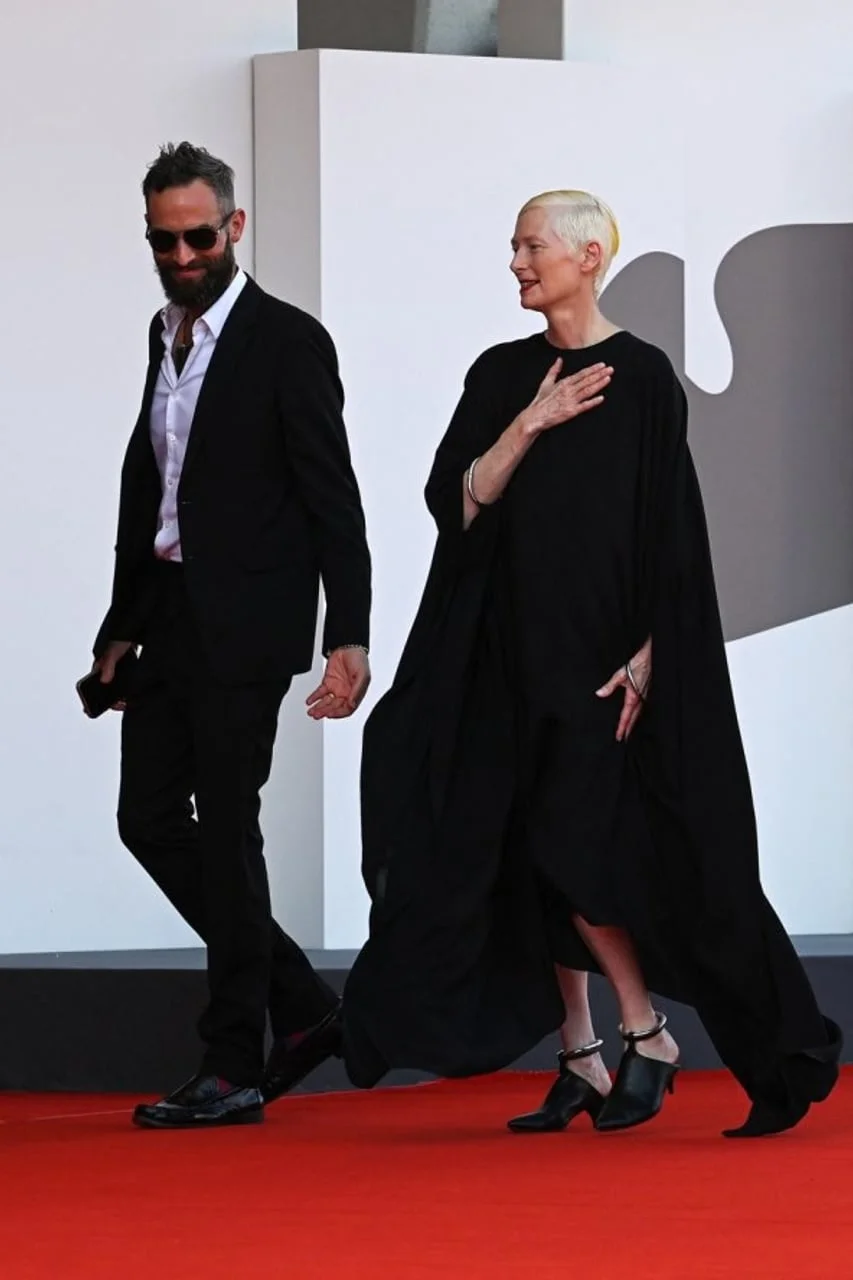 Tilda Swinton u crnoj haljini i partner u crnom odelu na događaju