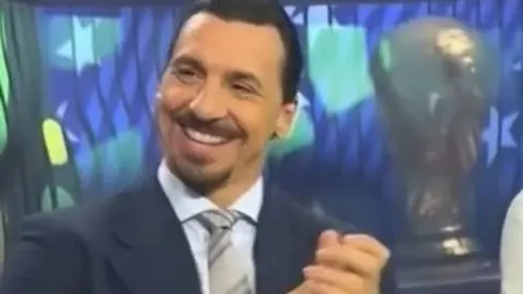 Zlatan Ibrahimović u tamnom odijelu smiješi se u studiju