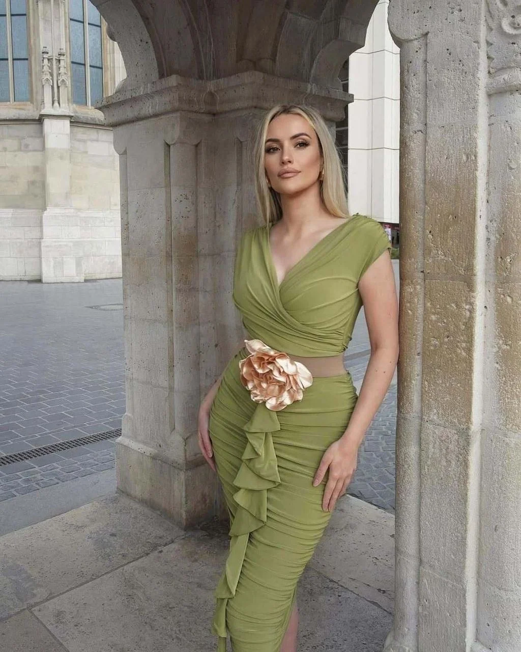 Žena u uskoj maslinasto zelenoj haljini s cvjetnim ukrasom