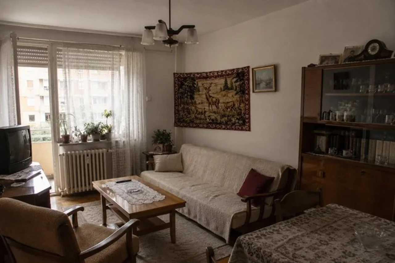 Vintage dnevni boravak s tkanim tepihom, drvenim namještajem i čipkama