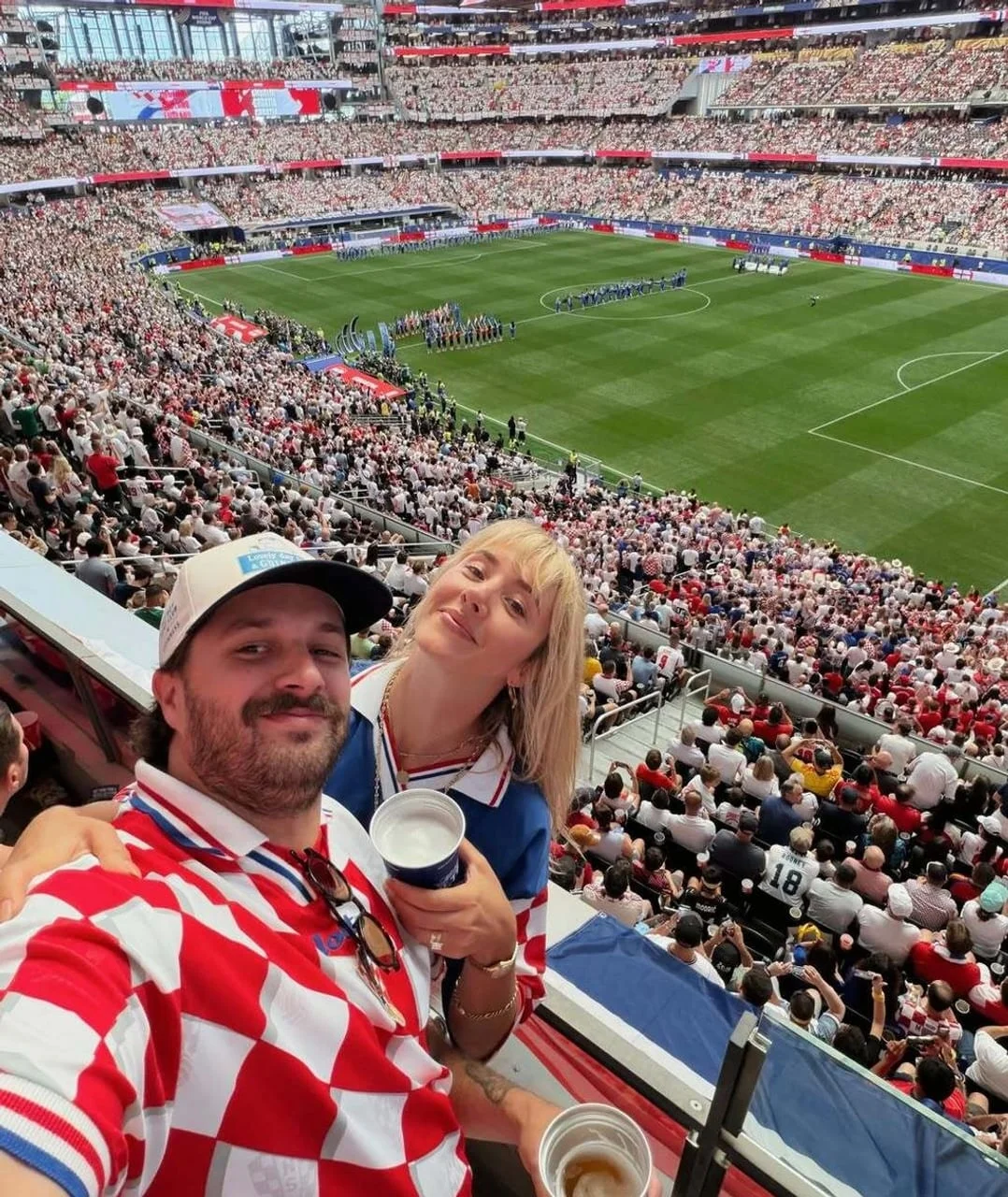 Selfie muškarca i žene u hrvatskim navijačkim majicama na tribinama