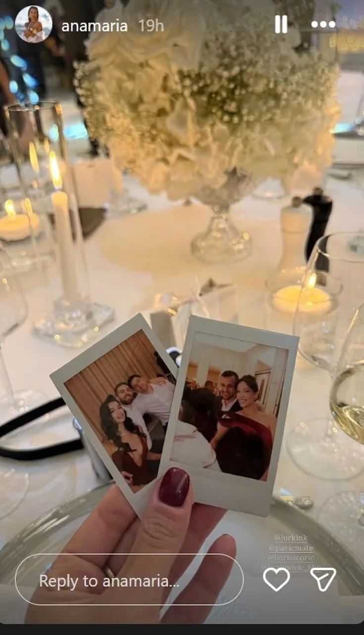 Ruka koja drži dvije polaroid fotografije uz bijela cvijeća