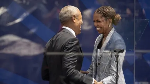Barack i Michelle Obama u elegantnim odjevama nasmijani jedno drugome