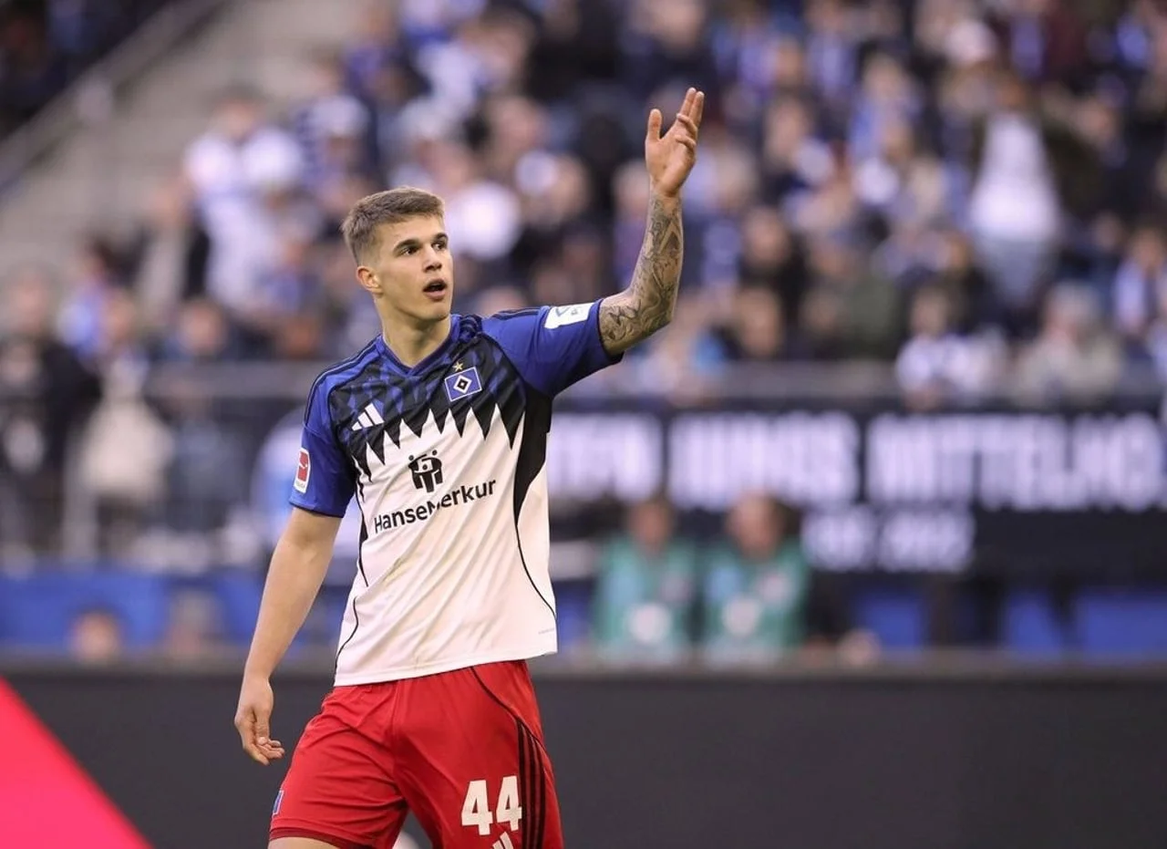 Luka Vušković u bijelo-plavom dresu i crvenim hlačama podiže ruku