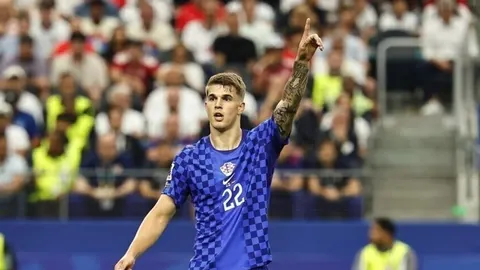 Luka Vušković u plavom dresu reprezentacije Hrvatske podiže ruku u znak slavlja