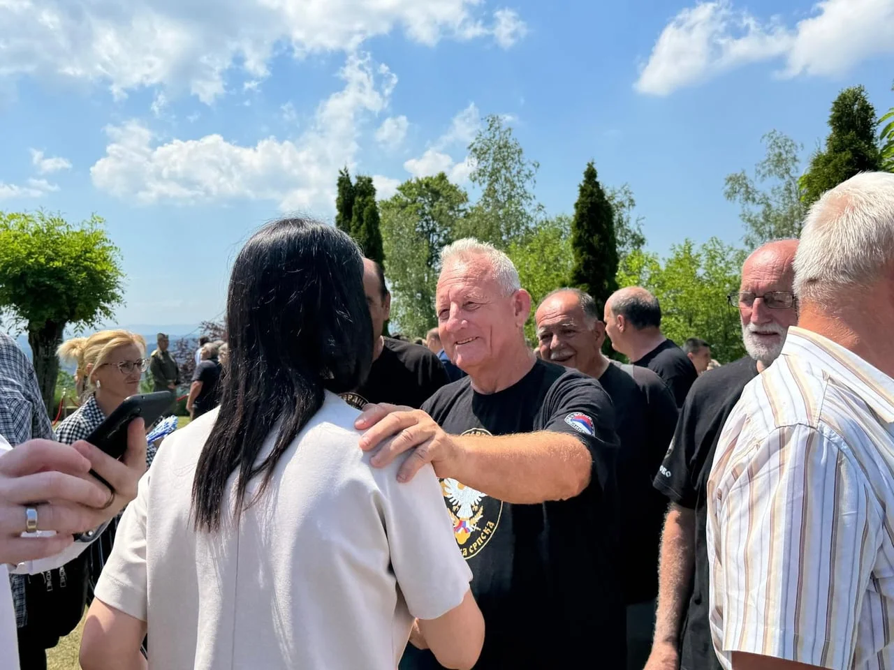 Muškarac u crnoj majici razgovara s ženom okrenutom leđima