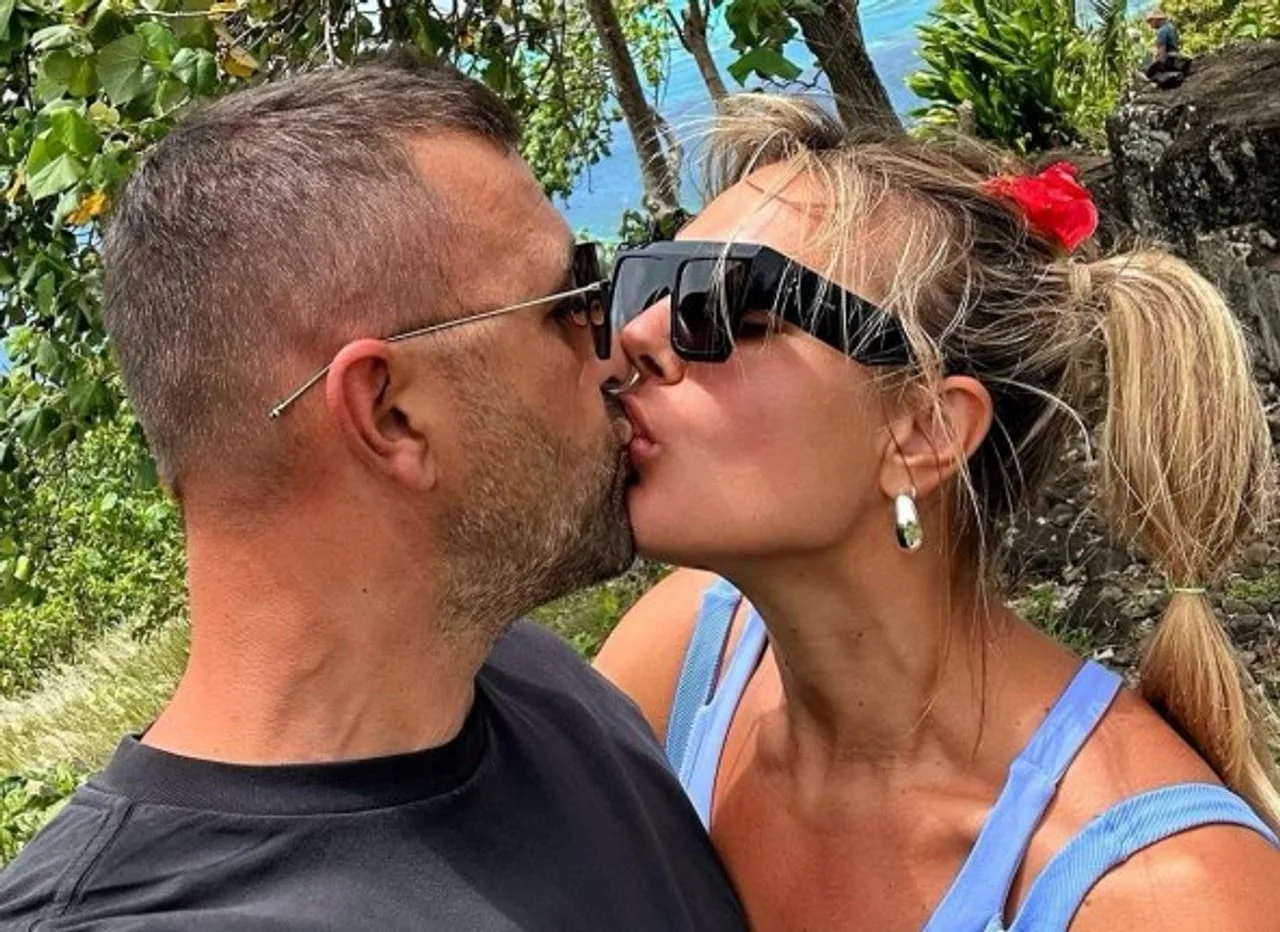 Muškarac i žena s sunčanim naočalama ljube se na otvorenom