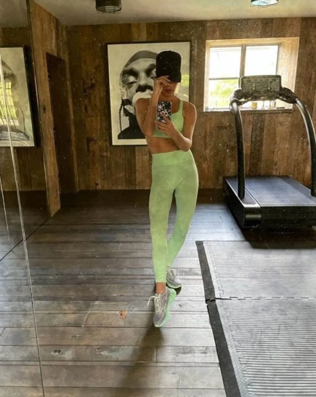 Victoria Beckham u zelenoj sportskoj odjeći pored traka za trčanje