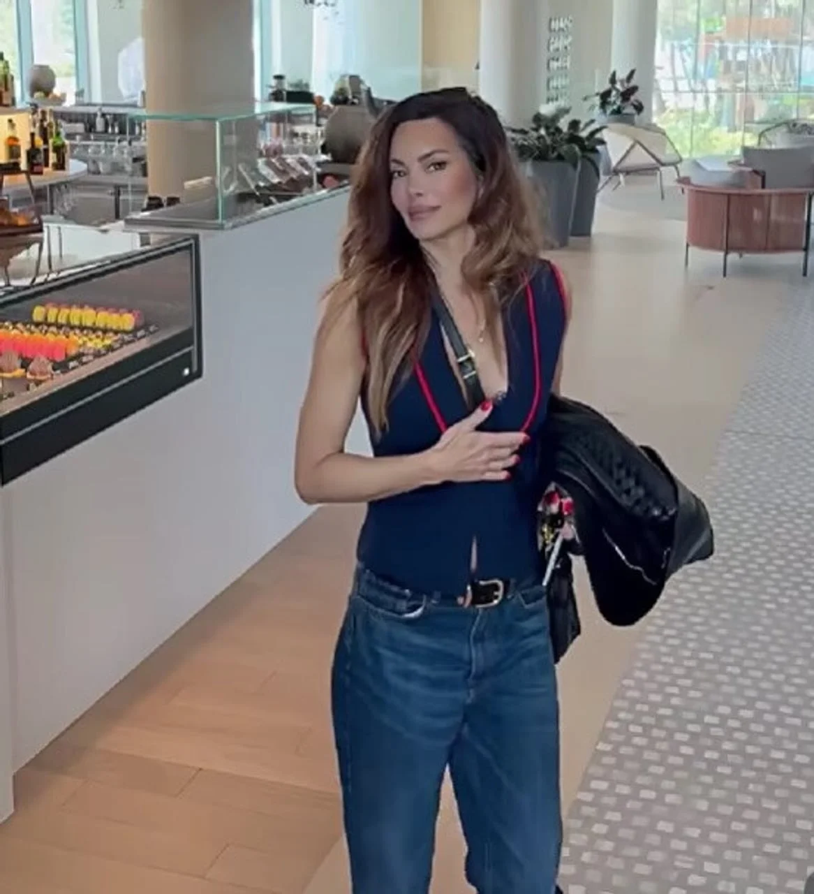 Nikolina Pišek u trapericama i plavom prsluku s crnim torbom