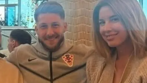 Marco Pašalić u trenerci Hrvatske i mlada žena koji se smiješe
