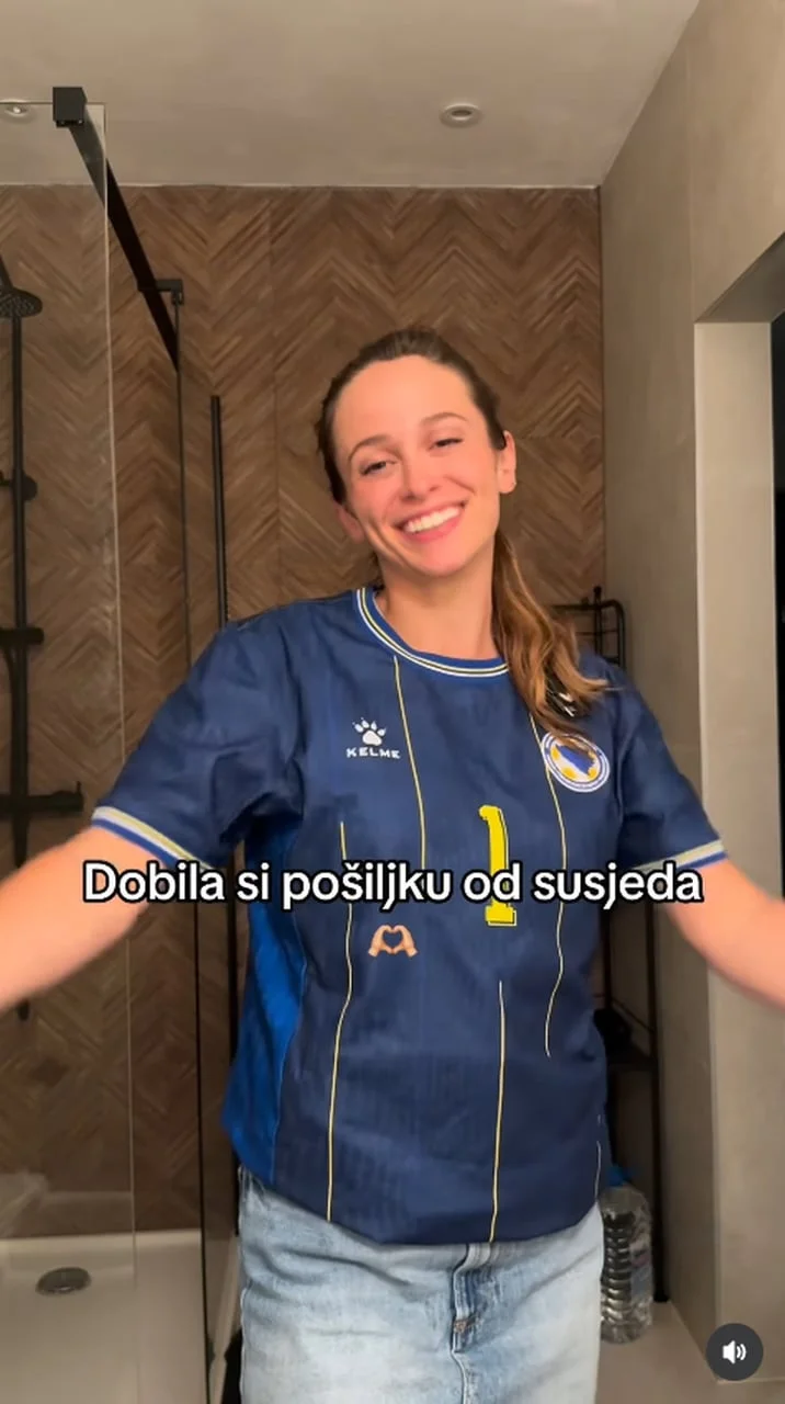Nasmijana žena u plavom nogometnom dresu