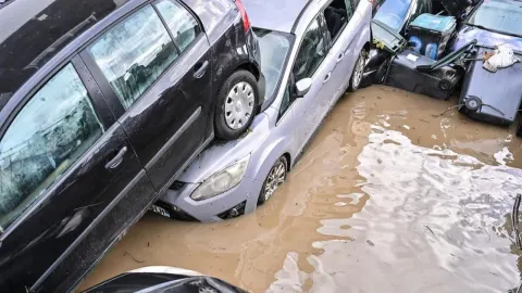Automobili naslagani jedan na drugi u dubokoj mutnoj vodi nakon poplave.