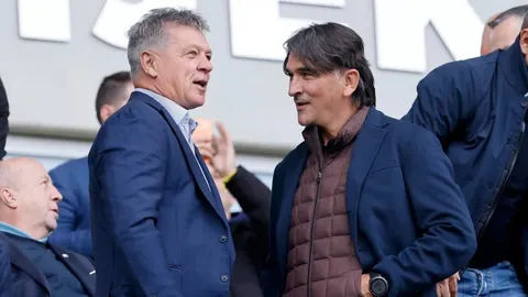 Ivan Turudić u plavom saku razgovara s muškarcem u smeđoj jakni