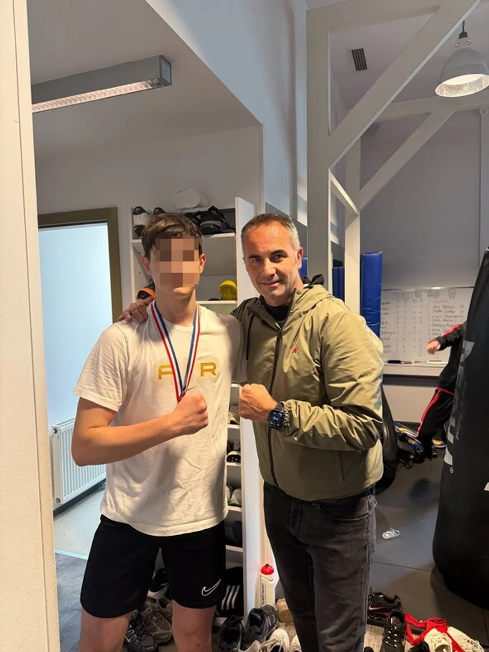 Joško Lokas i mladić s medaljom oko vrata u prostoriji