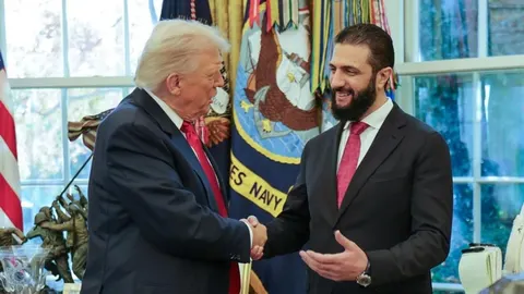 Donald Trump i Ahmed al-Šara u odelima rukuju se u uredu