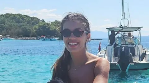 Nasmijana Nives Ivanišević s tamnim sunčanim naočalama na moru
